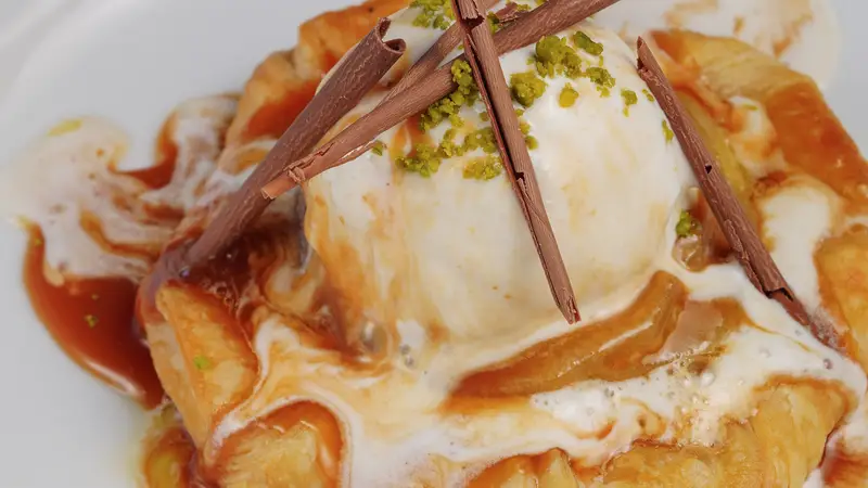 Warm apple pastry with vanilla ice cream, caramel drizzle, and chocolate shards – Apple Goldrush dessert