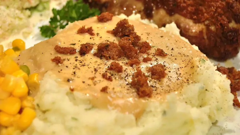 Creamy mashed potatoes with brown gravy and crispy bacon bits with corn on the side – LongHorn Mashed Potatoes