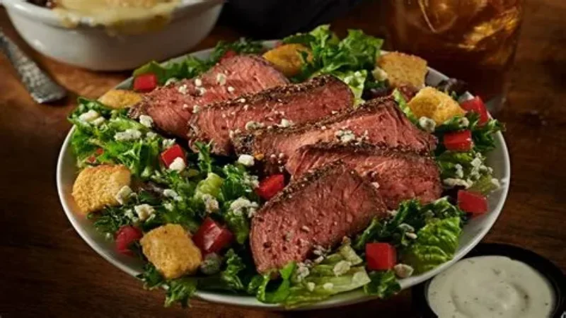 Grilled 7-pepper sirloin steak salad with green leaves and blue cheese